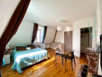 a bedroom with a bed and a table at Demeure des Dentelles in Le Puy-en-Velay