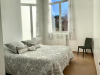 a white bedroom with a bed and a window at Demeure des Dentelles in Le Puy-en-Velay