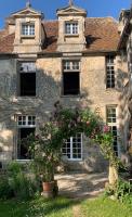 an old stone house with flowers in front of it at La Maison Saint Joseph in Crépy-en-Valois