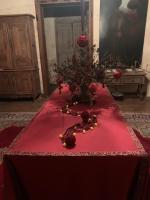 a table with a flower arrangement on a red table cloth at La Maison Saint Joseph in Crépy-en-Valois
