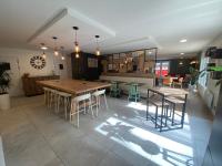 Una habitación grande con una mesa y sillas de madera. en Campanile Nantes ~ Rezé Aéroport, en Rezé