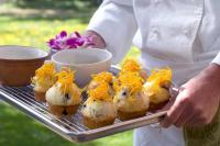 una persona sosteniendo una bandeja de comida en una parrilla en The Alpine House, en Jackson