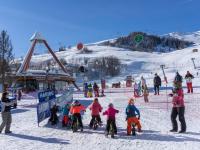 a group of children on bikes in the snow at Studio Pegase Phenix-44 by Interhome in Le Corbier