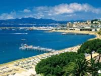 a beach with a pier and boats in the water at Apartment Cannes Bay-2 by Interhome in Cannes