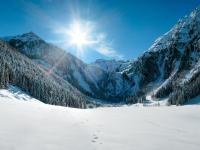 a snow covered mountain range with the sun in the sky at Apartment Poldi by Interhome in Haus im Ennstal