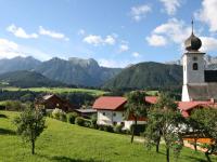 a church on a hill with mountains in the background at Apartment Poldi by Interhome in Haus im Ennstal