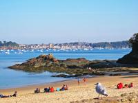 a group of people sitting on a beach at Studio La Garde by Interhome in Dinard