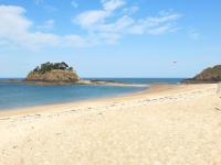 a sandy beach with an island in the water at Holiday Home La Vallée by Interhome in Cancale