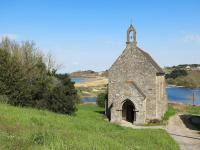 an old stone church on a hill next to a lake at Holiday Home La Vallée by Interhome in Cancale