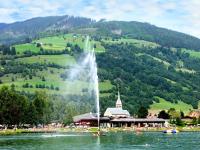 a fountain in the middle of a lake in front of a mountain at Apartment Appartment Wiesberg by Interhome in Niedernsill