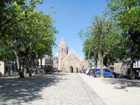 a church with cars parked on the side of a street at Holiday Home La Plage by Interhome in Denneville