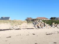 a pile of rocks on a sandy beach at Holiday Home La Plage by Interhome in Denneville