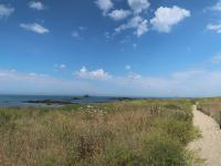 a path on a beach with the ocean in the background at Holiday Home Penn Ar Bed - PBA114 by Interhome in Pleubian