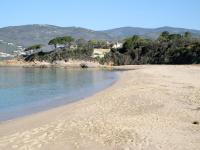 a sandy beach with houses in the background at Holiday Home La Pinede - SAG171 by Interhome in Sagone