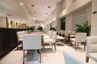 uma longa sala de jantar com cadeiras brancas e uma mesa longa em Samba Linhares em Linhares