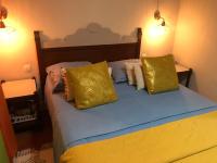 a bedroom with a bed with yellow and white pillows at Colibri des Rochers.Vue mer &amp; piscine.Anse des Rochers in Saint-François