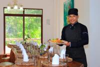 a man holding a plate of food at a table at Natura Gardens Galápagos in Bellavista