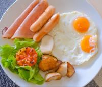a plate of breakfast food with eggs sausage and lettuce at Hotel Midtown Ratsada in Phuket Town