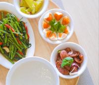 four bowls of food on a table with vegetables at Hotel Midtown Ratsada in Phuket Town