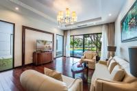 a living room with white furniture and a chandelier at Vinpearl Resort & Spa Phu Quoc in Phú Quốc