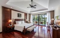 a bedroom with a bed and a desk and a window at Vinpearl Resort & Spa Phu Quoc in Phú Quốc