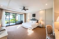 a bedroom with a white bed and a large window at Vinpearl Resort & Spa Phu Quoc in Phú Quốc