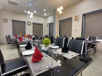 een vergaderzaal met tafels en stoelen met rode servetten bij Vadpadraka Hotel And Resort in Vadodara