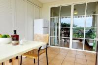 a kitchen with a table and a refrigerator at Studio &quot;Prestige&quot; Sainte Luce in Sainte-Luce