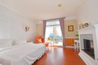 a bedroom with a white bed and a fireplace at Ming Ging Farm in Ren&#39;ai