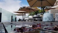 a pool of water with tables and chairs and umbrellas at Ming Ging Farm in Ren&#39;ai