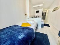 a bedroom with a large bed with a yellow pillow at L&#39;Oasis Montparnasse in Paris