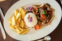 a plate of food with rice and french fries at Hotel Miramar in Lima