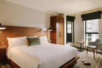 ein Schlafzimmer mit einem großen weißen Bett und einem Stuhl in der Unterkunft FOUND Hotel, Santa Monica in Los Angeles