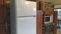 a refrigerator in a kitchen next to a microwave at Gite la Péraie - Le Roseau in Treize-Vents