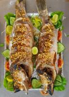 three pieces of fish on a plate with vegetables at Happy Shack Beach And Wooden Huts in Colva