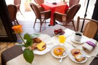 un tavolo con due piatti di prodotti per la colazione e una tazza di caffè di Hotel Gabriella a Rimini