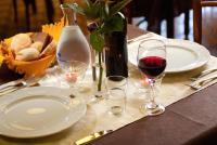 un tavolo con piatti bianchi e bicchieri di vino di Hotel Gabriella a Rimini