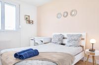 a white bedroom with a bed with blue towels on it at Appartement Prestige - Amiens in Amiens
