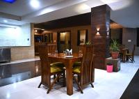 Un comedor con mesa y sillas de madera. en Shubhim Hotel & Resort MIDWAY TREAT MPT FRANCHISE, en Gwalior