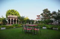 una mesa y sillas en un jardín con cenador en Shubhim Hotel & Resort MIDWAY TREAT MPT FRANCHISE, en Gwalior
