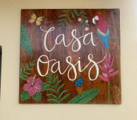 una señal de madera con un pájaro y una señal que saysla casitas en Casa Oasis, en Leticia