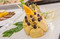 イアリソスにあるIALYSSOS BAY HOTELの黒豆が乗ったデザートが載った白い皿