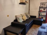 a black leather couch in a living room at Maison familiale, 15couchages, de charme au cœur de la Bretagne - 20 min de Vannes in Lizio