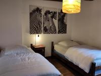 a bedroom with two beds and a painting of zebras at Maison familiale, 15couchages, de charme au cœur de la Bretagne - 20 min de Vannes in Lizio