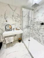 a white bathroom with a sink and a shower at Appt vu sur un parc privatif à 20 min de Paris in Saint-Leu-la-Forêt