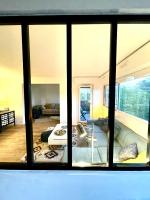 a view of a living room through a window at Appt vu sur un parc privatif à 20 min de Paris in Saint-Leu-la-Forêt