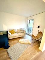 a living room with a couch and a rug at Appt vu sur un parc privatif à 20 min de Paris in Saint-Leu-la-Forêt