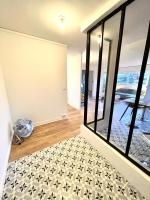 a living room with a large glass door and a floor at Appt vu sur un parc privatif à 20 min de Paris in Saint-Leu-la-Forêt