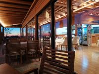 a restaurant with tables and chairs and windows at Te Aldo Hotel in Durrës
