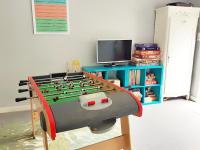 a toy foosball table in a room with a tv at Villa Saint Kirio - piscine et spa in Morlaix